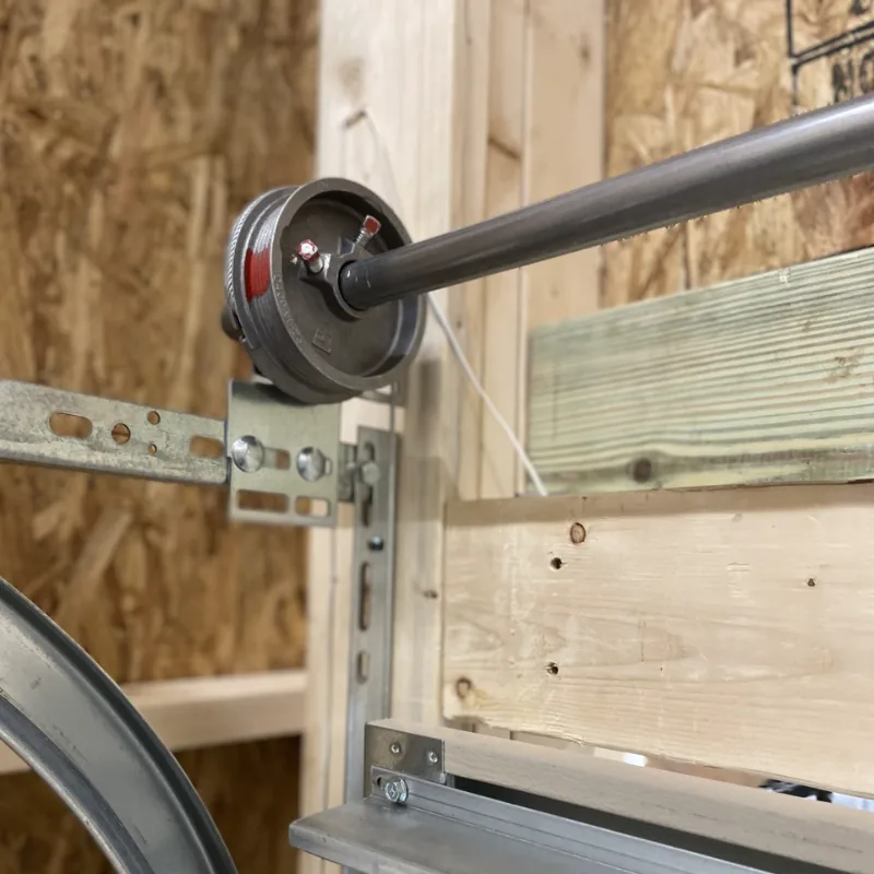 A garage door lift cable on the cable drum at the top corner of the door