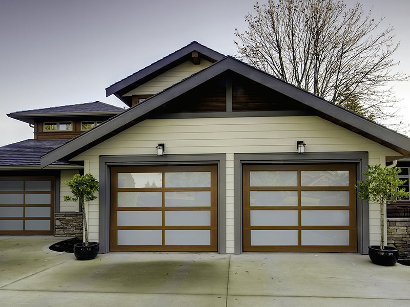 Modern full-view garage doors with frosted glass and wood-tone frames