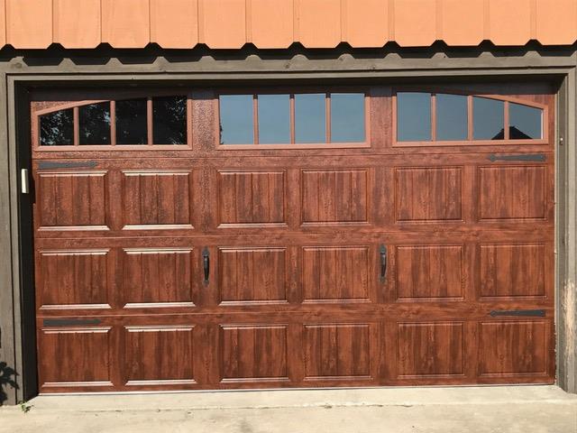 Oak wood-look garage door with arched windows and black handles