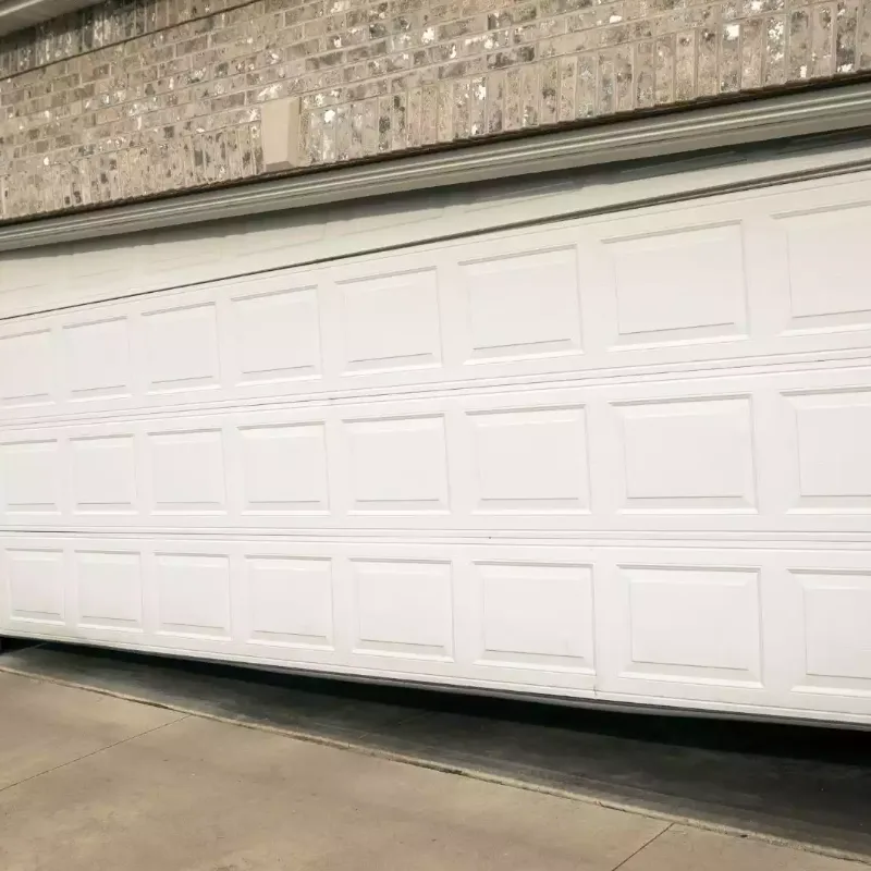 A white garage door that hangs crooked in its opening, with an uneven gap at the bottom
