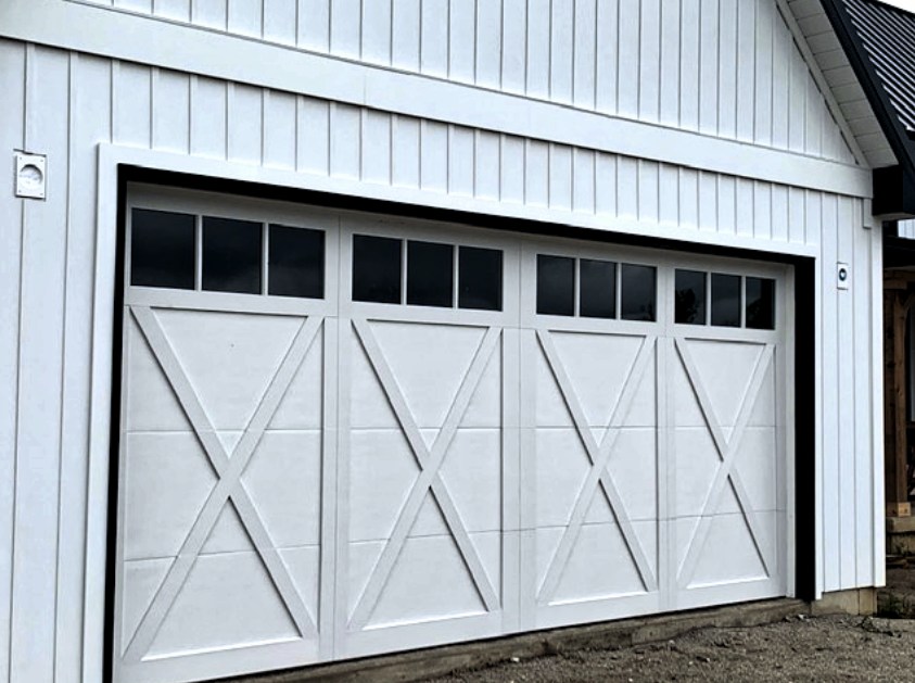 White carriage house garage door with X trim and a row of windows